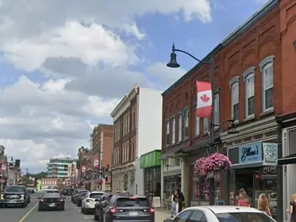 Brick storefronts and a Canadian flag on Dundas Street in historic downtown Napanee